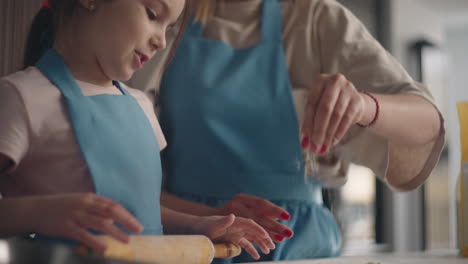 cute-little-girl-is-rolling-out-dough-for-pie-child-is-helping-to-mother-cooking-in-kitchen